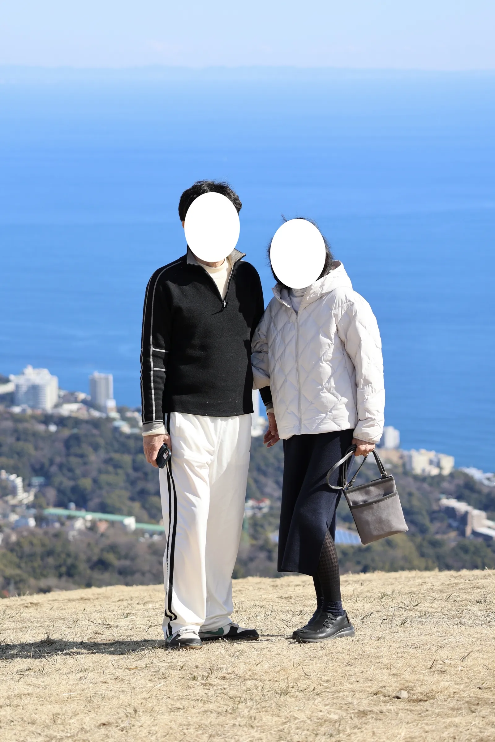 My parents standing with Suruga Bay and the streets of Atami behind them