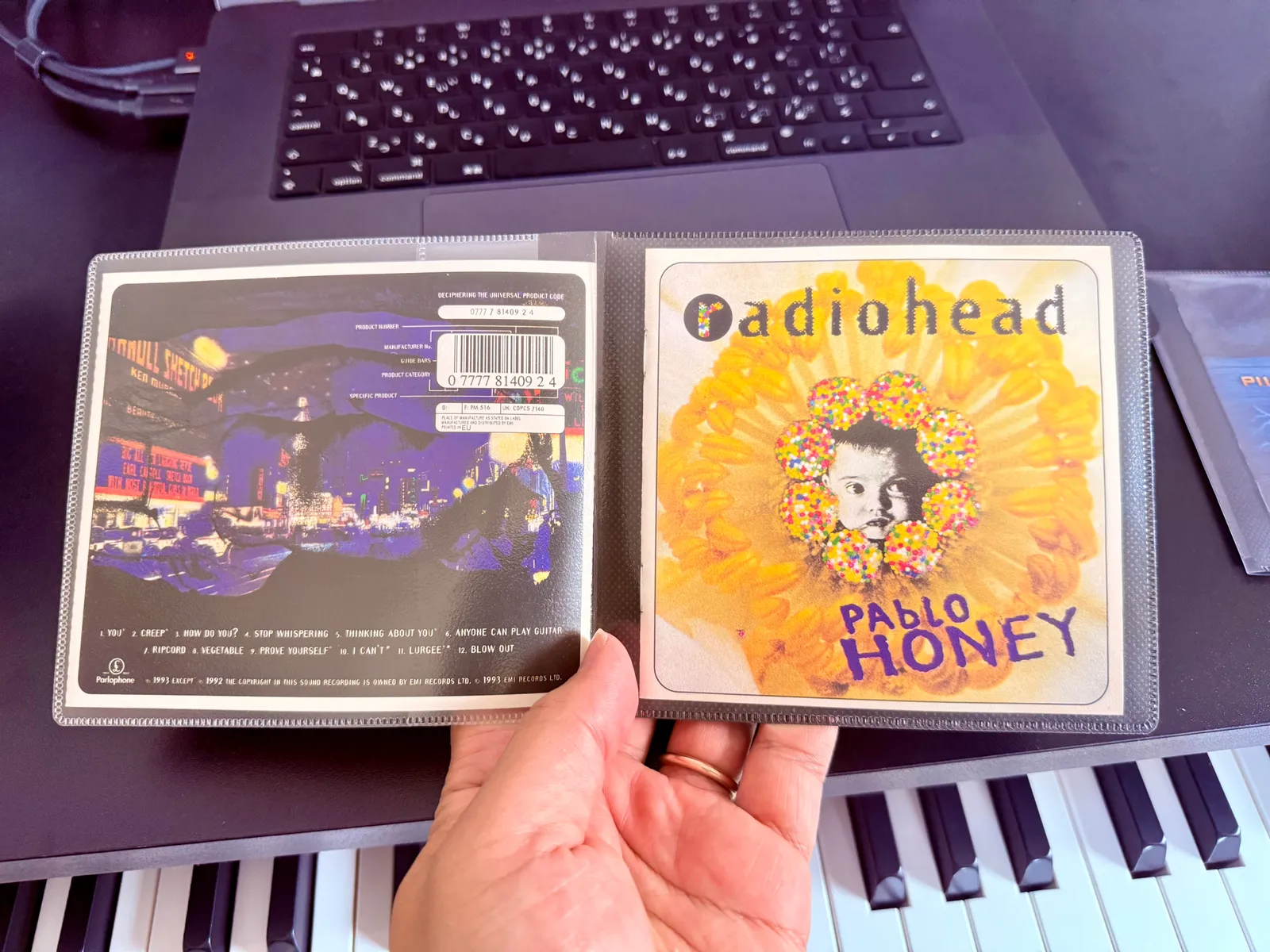 A slim case opened, showing the back inlay on the left and the jacket art on the right (Radiohead — Pablo Honey)